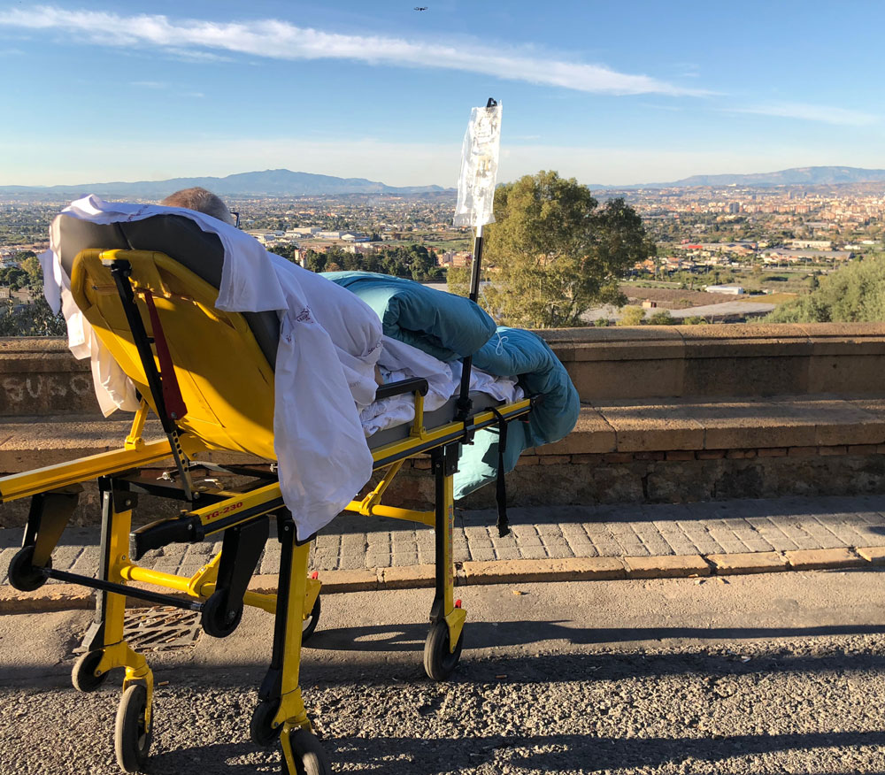 Antonio observa las vistas desde el Santuario al que ha llegado, tumbado en su camilla, con la Ambulancia del Deseo.